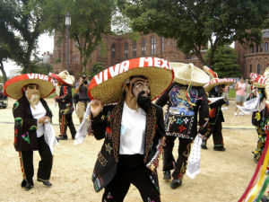Members of Los Tecuanes from Manassas, Virginia dance in front of the Smithsonian Castle during the 2004 Smithsonian Folklife Festival on the National Mall. (Richard Strauss/Smithsonian Institution)