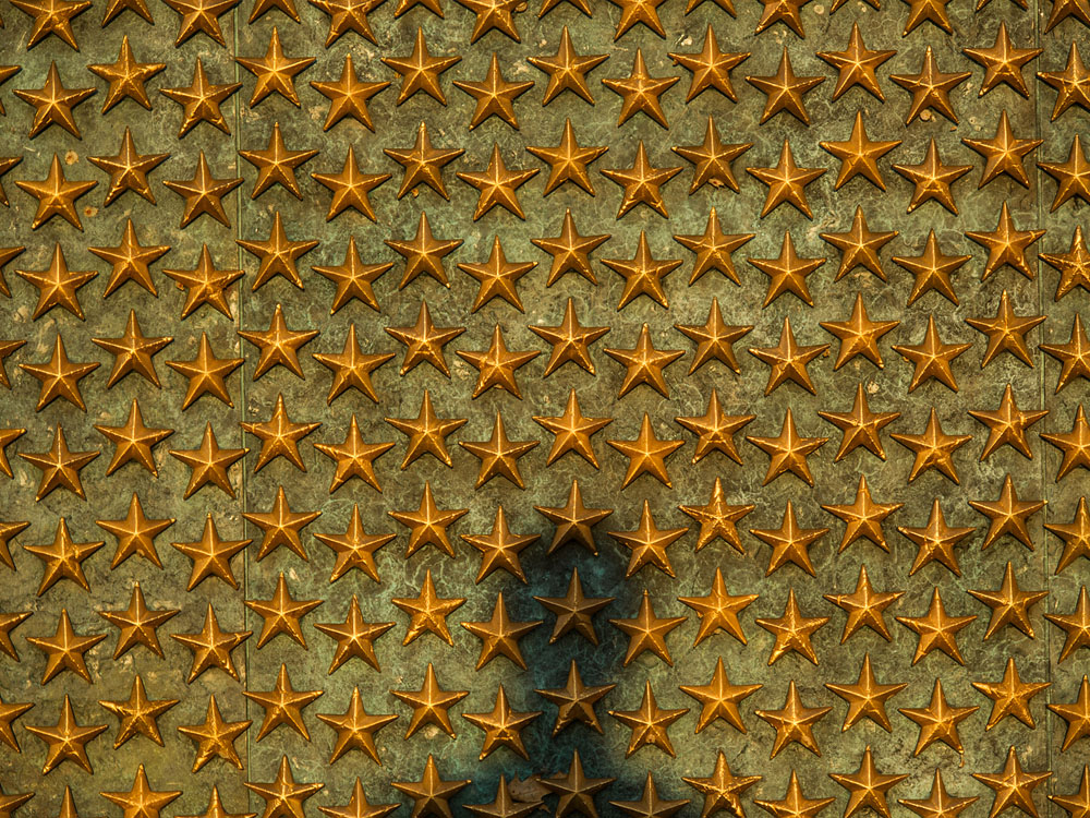 A shadow appears on the wall of stars at the National World War II Memorial, June 20, 2014 in Washington D.C. The World War II Memorial honors the 16 million who served in the armed forces of the U.S., the more than 400,000 who died, and all who supported the war effort from home. (U.S. Air Force photo by Senior Airman James Richardson)