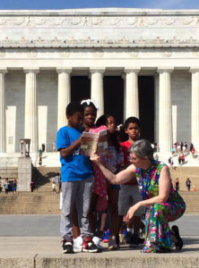 Students from Shining Stars Montessori Academy, with help from teacher Louise Parker Kelley, read their essays from the book "Called to the Mall: An Anthology of Stories About the Mall" at the Lincoln Memorial in Washington, D.C.
