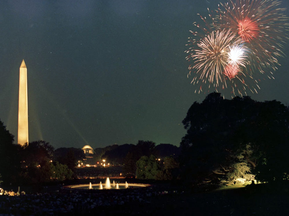 A large audience of White House Staff members watch Fourth of July fireworks from the grounds at the White House. (Courtesy White Houe Press Photographer)